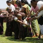 Buddhist monks walk down a road asking for alms to mark Vesak festival in Colombo