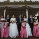 Chinese wedding couples pose for photographs during a mass wedding ceremony for fifty Chinese couples in Colombo