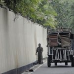 A tracktor transports sunbathing chair from a hotel on a road towards tourist hotels in Bentota